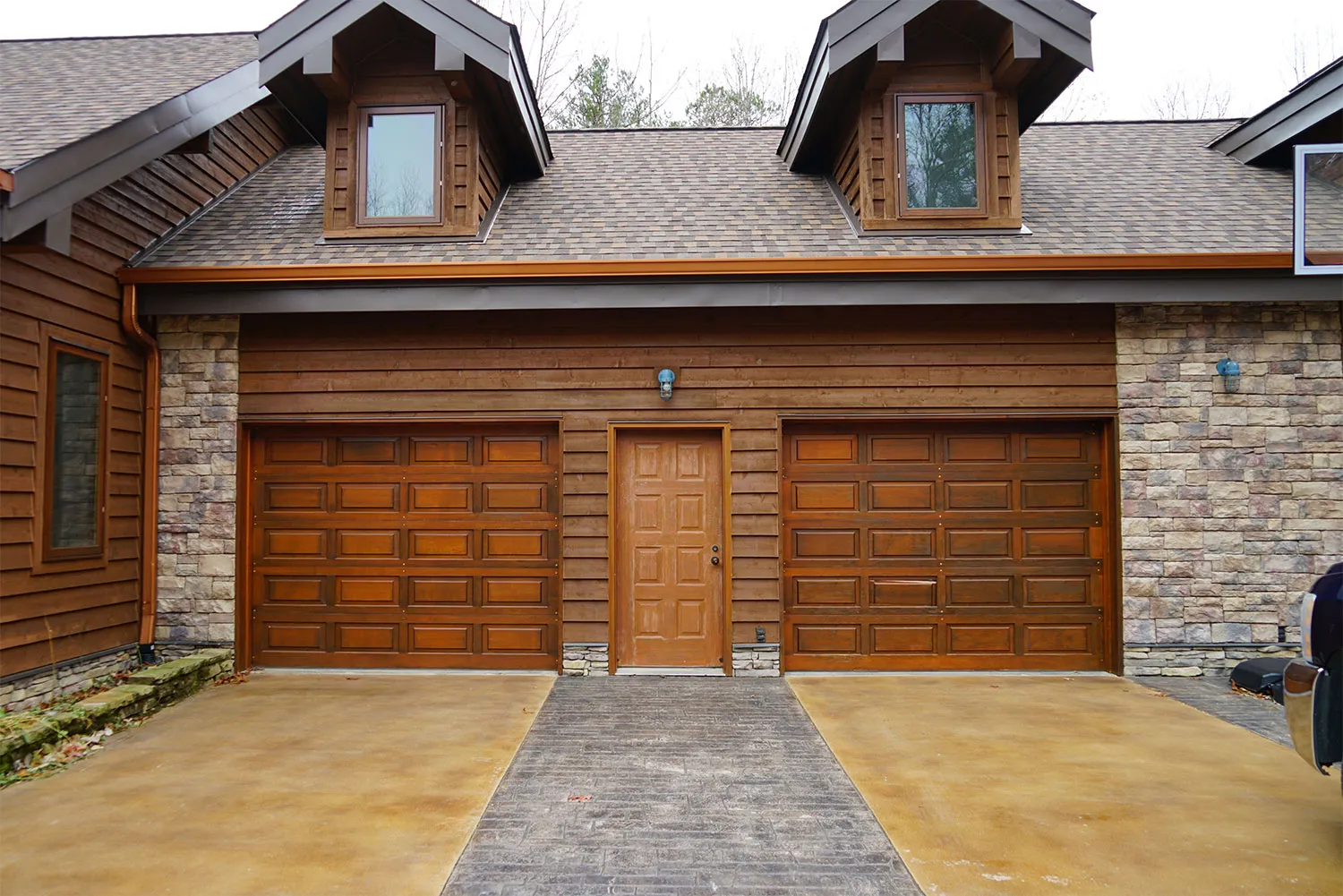 The same home before: older raised-panel garage doors